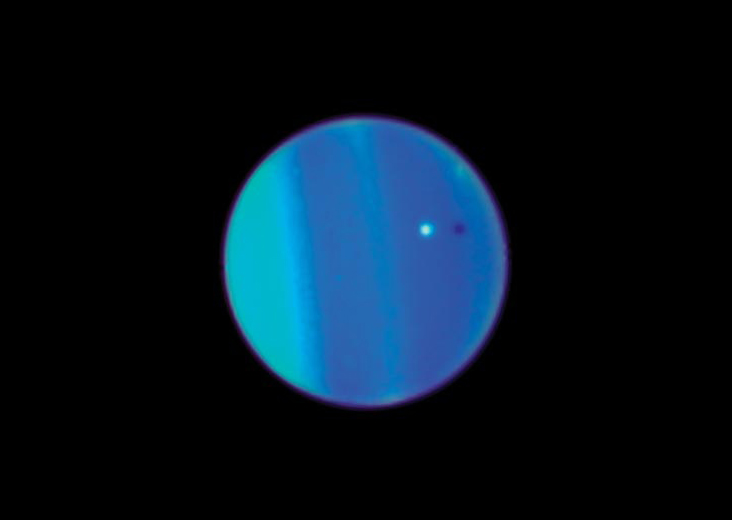 Urano col suo satellite Ariel in una immagine dal sito della Nasa