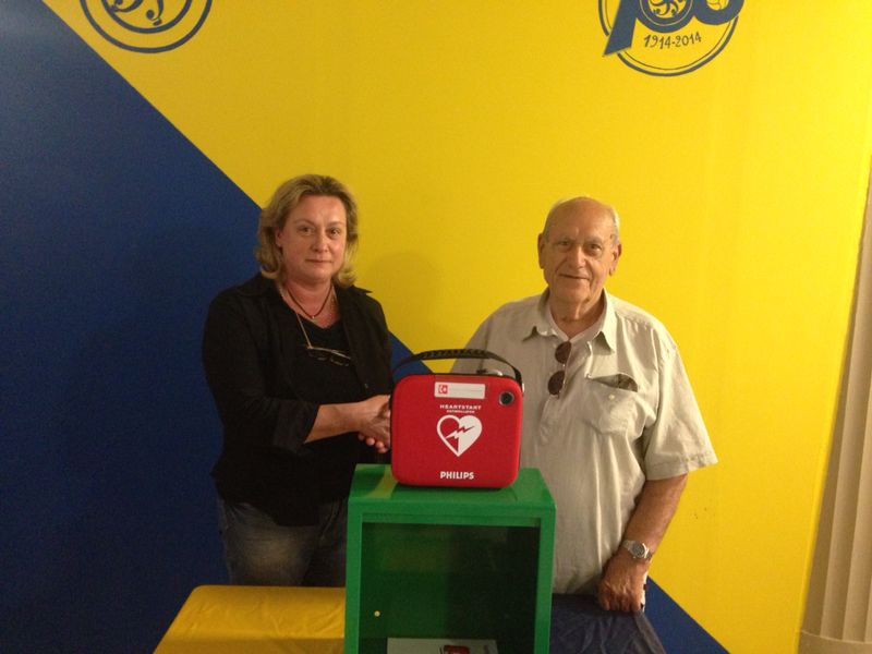 Il dirigente Fabio Pandolfini riceve il defibrillatore da una delle mamme che fanno parte dell'associazione