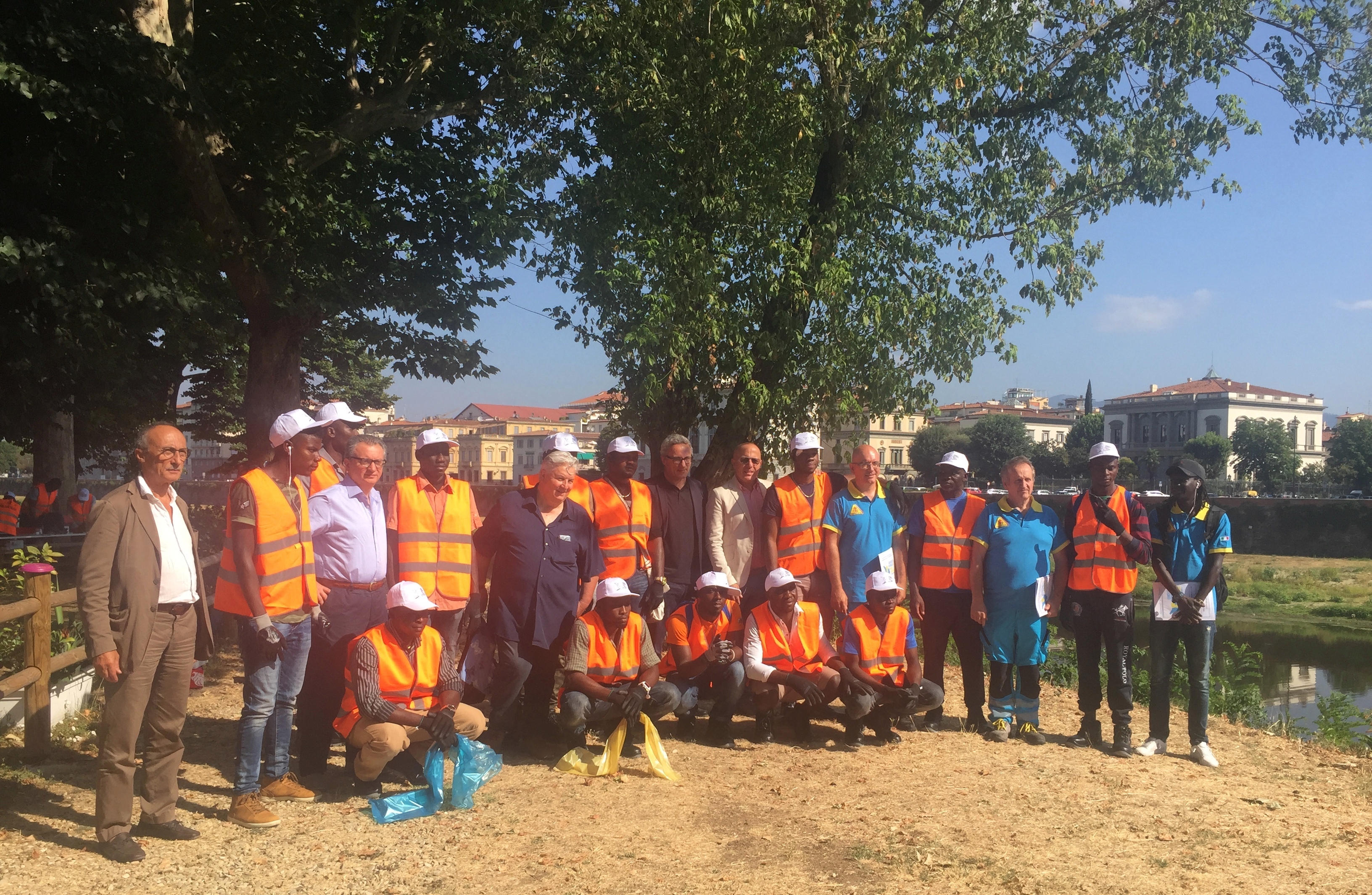 migranti all'opera per pulire le sponde dell'Arno